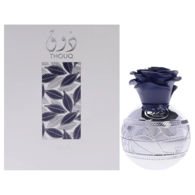 Lattafa Pride Thouq edp perfume bottle in a decorative glass container next to grey packaging background white surface