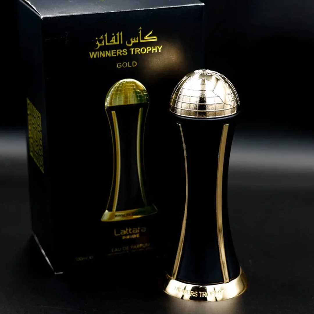 Lattafa Pride Al Khas Winners Trophy Gold 100ml — A dark blue box with gold text and a matching dark blue and gold globe-topped perfume bottle, displayed against a white background. | Lattafa Pride Al Khas Winners Trophy Gold 100ml — Kotak biru gelap dengan teks emas dan botol minyak wangi bertopi dunia biru gelap dan