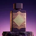 Lattafa Bade'e Al Oud Amethyst Fusion 100ml — A purple perfume bottle with a dark grey cap and a gold and light green geometric label. | Lattafa Bade'e Al Oud Amethyst Fusion 100ml — Botol minyak wangi ungu dengan penutup kelabu gelap dan label geometri emas dan hijau muda.