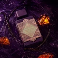 Lattafa Bade'e Al Oud Amethyst Fusion 100ml — A purple perfume bottle with a dark grey cap and a gold and light green geometric label. | Lattafa Bade'e Al Oud Amethyst Fusion 100ml — Botol minyak wangi ungu dengan penutup kelabu gelap dan label geometri emas dan hijau muda.
