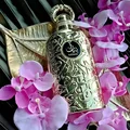 Lattafa Bayaan Eau De Parfum 100ml by Lattafa — A golden perfume bottle with intricate Arabic calligraphy design, presented in a white box with a matching golden outer sleeve featuring similar calligraphy. | Lattafa Bayaan Eau De Parfum 100ml by Lattafa — Botol minyak wangi emas dengan reka bentuk kaligrafi Arab yang