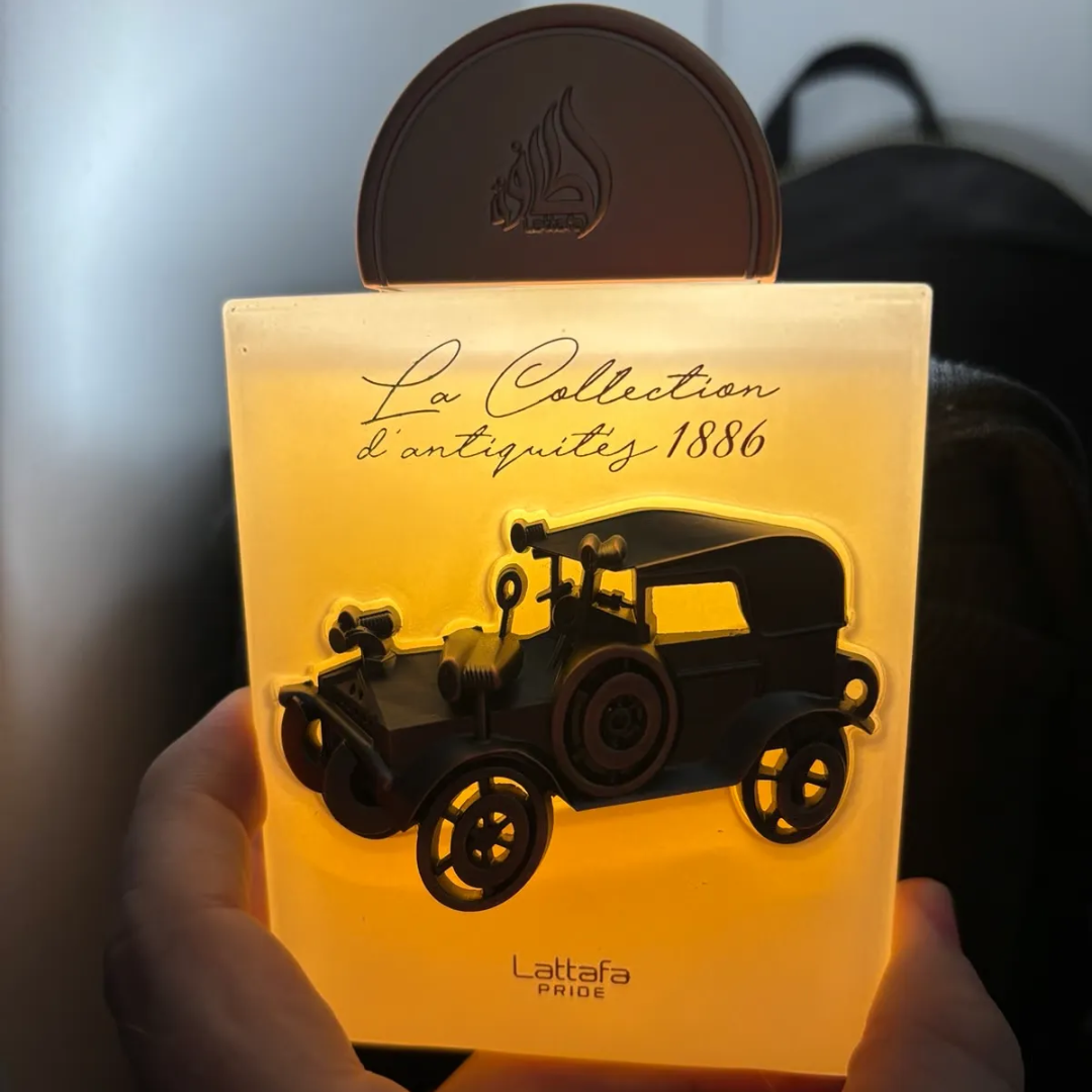 La Collection 1886 Car Lattafa Pride boxed fragrance in hand side view closeup low light