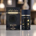 Lattafa Khalta Blend Of Lattafa Eau De Parfum 100ml — A dark blue perfume bottle with a textured, carved outer layer revealing gold accents inside, next to its matching cap with a gold circular emblem. | Lattafa Khalta Blend Of Lattafa Eau De Parfum 100ml — Botol minyak wangi biru gelap dengan lapisan luar bertekstur
