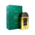 Lattafa Pride Maharjan Gold — A gold perfume bottle with a black mosaic cap and decorative panel sits next to its matching dark green embossed box. | Lattafa Pride Maharjan Gold — Botol minyak wangi emas dengan penutup mozek hitam dan panel hiasan duduk di sebelah kotak hijau gelapnya yang bertebuk.