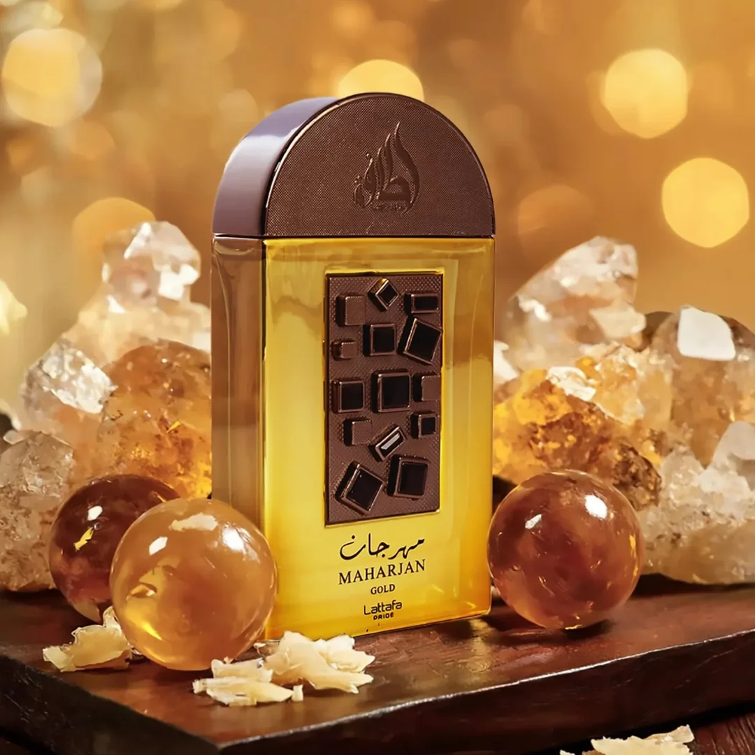 Lattafa Pride Maharjan Gold — A gold perfume bottle with a black mosaic cap and decorative panel sits next to its matching dark green embossed box. | Lattafa Pride Maharjan Gold — Botol minyak wangi emas dengan penutup mozek hitam dan panel hiasan duduk di sebelah kotak hijau gelapnya yang bertebuk.