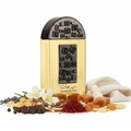 Lattafa Pride Maharjan Gold — A gold perfume bottle with a black mosaic cap and decorative panel sits next to its matching dark green embossed box. | Lattafa Pride Maharjan Gold — Botol minyak wangi emas dengan penutup mozek hitam dan panel hiasan duduk di sebelah kotak hijau gelapnya yang bertebuk.