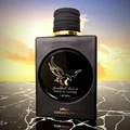 Lattafa Malik Al Tayoor Concentrated 100ml — Black perfume bottle with gold cap and eagle emblem, next to its black and gold patterned box with matching emblem. | Lattafa Malik Al Tayoor Concentrated 100ml — Botol minyak wangi hitam dengan penutup emas dan lambang helang, bersebelahan kotak corak hitam dan emasnya