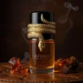 Lattafa Musamam Eau De Parfum 100ml by Lattafa — A golden snake coils around a clear glass perfume bottle filled with amber liquid, next to a textured brown cylindrical case with a snake-skin pattern. | Lattafa Musamam Eau De Parfum 100ml by Lattafa — Ular emas melilit botol minyak wangi kaca jernih berisi cecair