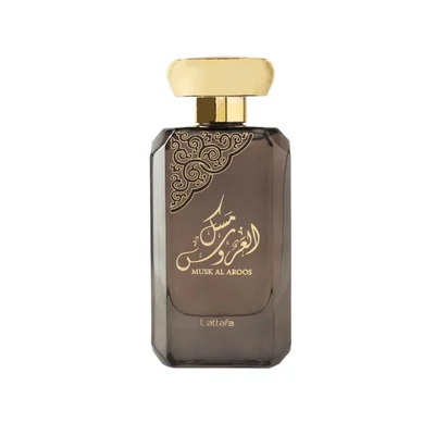 Lattafa Musk Al Aroos — A dark blue perfume bottle with gold Arabic calligraphy and 'MUSK AL AROOS LATTAFA' text, presented in an open dark blue gift box with a black velvet insert. | Lattafa Musk Al Aroos — Botol minyak wangi biru gelap dengan kaligrafi Arab emas dan teks 'MUSK AL AROOS LATTAFA', dipersembahkan dalam