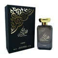Lattafa Musk Al Aroos — A dark blue perfume bottle with gold Arabic calligraphy and 'MUSK AL AROOS LATTAFA' text, presented in an open dark blue gift box with a black velvet insert. | Lattafa Musk Al Aroos — Botol minyak wangi biru gelap dengan kaligrafi Arab emas dan teks 'MUSK AL AROOS LATTAFA', dipersembahkan dalam