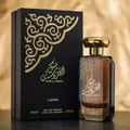 Lattafa Musk Al Aroos — A dark blue perfume bottle with gold Arabic calligraphy and 'MUSK AL AROOS LATTAFA' text, presented in an open dark blue gift box with a black velvet insert. | Lattafa Musk Al Aroos — Botol minyak wangi biru gelap dengan kaligrafi Arab emas dan teks 'MUSK AL AROOS LATTAFA', dipersembahkan dalam