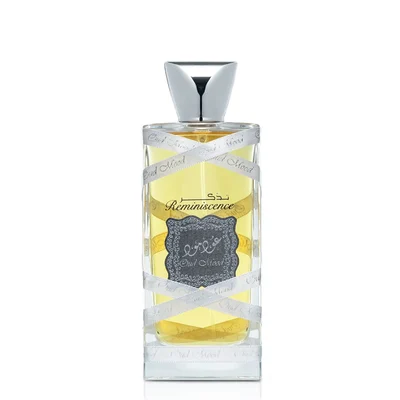 Lattafa Oud Mood Reminiscence 100ml — A cylindrical grey box with silver ornate patterns and a silver ribbon handle stands next to a clear glass perfume bottle with a silver cap, wrapped in white ribbon. | Lattafa Oud Mood Reminiscence 100ml — Kotak kelabu silinder dengan corak perak berhias dan pemegang reben perak