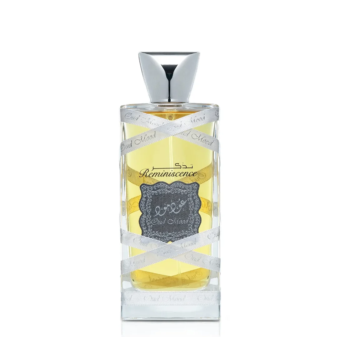 Lattafa Oud Mood Reminiscence 100ml — A cylindrical grey box with silver ornate patterns and a silver ribbon handle stands next to a clear glass perfume bottle with a silver cap, wrapped in white ribbon. | Lattafa Oud Mood Reminiscence 100ml — Kotak kelabu silinder dengan corak perak berhias dan pemegang reben perak