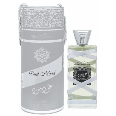 Lattafa Oud Mood Reminiscence 100ml — A cylindrical grey box with silver ornate patterns and a silver ribbon handle stands next to a clear glass perfume bottle with a silver cap, wrapped in white ribbon. | Lattafa Oud Mood Reminiscence 100ml — Kotak kelabu silinder dengan corak perak berhias dan pemegang reben perak