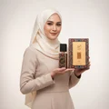 Woman in hijab holding Ajwad Lattafa edp fragrance spray white background closeup