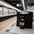 Asad Lattafa edp black bag on train platform bench gold accents closeup