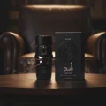 Asad Elixir Lattafa black fragrance wooden table beside brown leather chair smoke rising