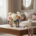 Azeezah Lattafa blue glass fragrance coffee table surrounded flowers cup books pearls