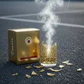 Emeer Lattafa gold packaging on asphalt surrounded smoke broken glass pieces nearby
