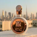 Fakhar Rose Gold Lattafa perfume bottle rooftop city skyline sunset closeup side angle