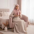 Woman in hijab holding Hayaati Florence Lattafa edp pink fragrance chair bedroom