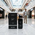 Hayaati Men Lattafa black perfume bottle marble table shopping mall walking people