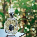 Lattafa rouat al musk women's fragrance in ornate clear glass elegant outdoor setting closeup shot