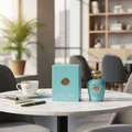 Opulent Dubai Lattafa unisex fragrance on table next teacup notebook pen office setting