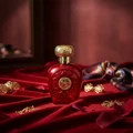 Opulent Red Lattafa unisex fragrance elegant setting velvet cloth surrounded gold accessories