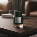 Qaaed Intense Lattafa edp perfume green bottle dark wooden table near brown sofa