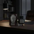 Qaaed Intense Lattafa perfume bottle and box dark wooden table near black lamp