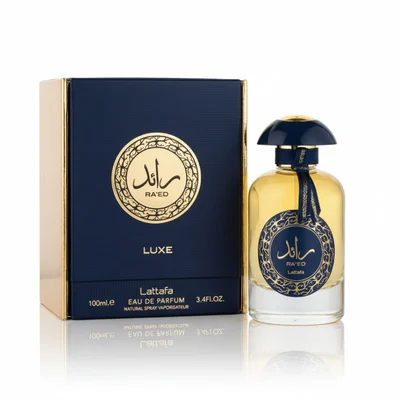 Raed Luxe Lattafa perfume bottle beside navy blue packaging white background closeup side view gold accents