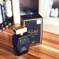 Lattafa raghba black gold men's fragrance edp on wooden table closeup view side perspective