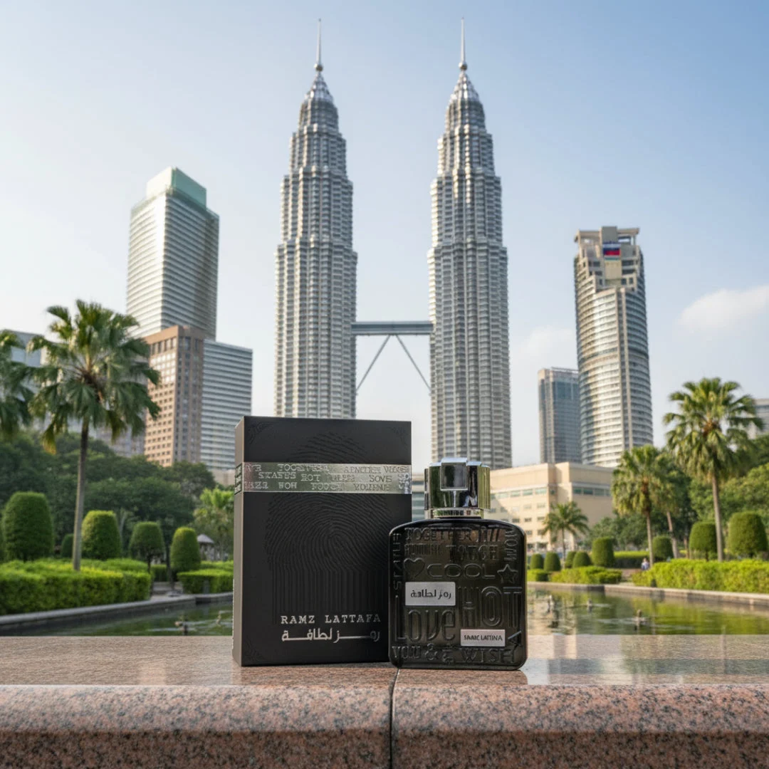 Lattafa Ramz Silver perfume bottle on ledge overlooking Kuala Lumpur cityscape background park palm trees skyscrapers