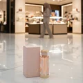 Teriaq Lattafa unisex edp pink glass fragrance bottle white floor mall background
