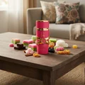 Yara Candy Lattafa pink gold perfume bottle wooden table surrounded colourful traditional Malay desserts