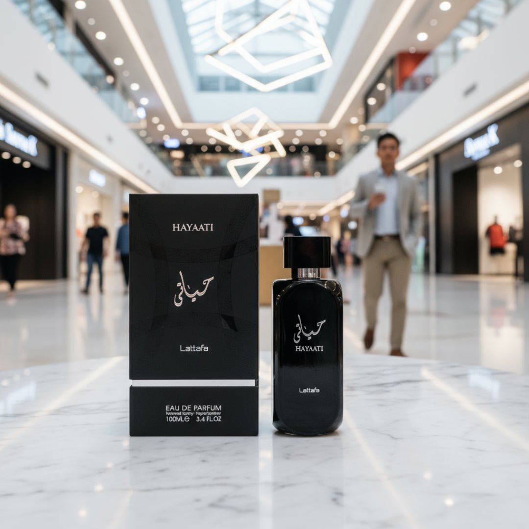 Hayaati Men Lattafa botol perfume hitam, meja marmar, orang berjalan