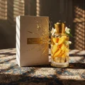 Ajayeb Dubai Portrait Lattafa edp glass bottles on table white boxes flower