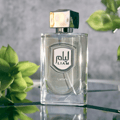 Liam Grey Lattafa edp clear glass fragrance reflective surface green leaves closeup