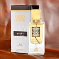 Lattafa Ana Abiyedh Leather 60ml — White perfume box and glass bottle with gold accents and Arabic calligraphy, showing the product packaging and bottle design. | Kotak minyak wangi putih dan botol kaca dengan aksen emas dan kaligrafi Arab, menunjukkan pembungkusan produk dan reka bentuk botol.