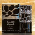 Lattafa Qimmah Eau De Parfum for Men 100ml — A black and silver perfume box with a pattern of irregular black shapes on a silver background, next to a black perfume bottle with a silver cap featuring a similar pattern. | Lattafa Qimmah Eau De Parfum for Men 100ml — Kotak minyak wangi hitam dan perak dengan corak