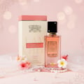 Ana Abiyedh Coral Lattafa edp dikelilingi bunga merah jambu latar pastel dekat