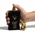 Tangan pegang Al Noble Ameer Lattafa hitamemas kepala rusa spray dekat sudut
