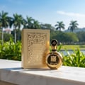 Botol Fakhar Extrait Lattafa, minyak wangi lelaki, pembungkusan emas, latar marmer, taman