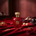 Opulent Red Lattafa unisex fragrance elegant setting velvet cloth surrounded gold accessories
