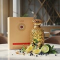 Emeer Lattafa gold woody scent perfume on table surrounded lemons blueberry lime