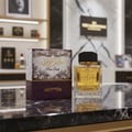 Khalis Pure Oudi Lattafa edp perfume glass on marble table next purple packaging