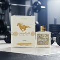 Qaed Al Fursan Lattafa edp atas lantai gym dekat kotak botol spray