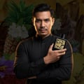 Man in black shirt holding Qaed Al Fursan Lattafa cologne close up portrait style