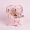 Lattafa Rouat Al Musk women's fragrance in pink case surrounded by jewels petals soft background closeup